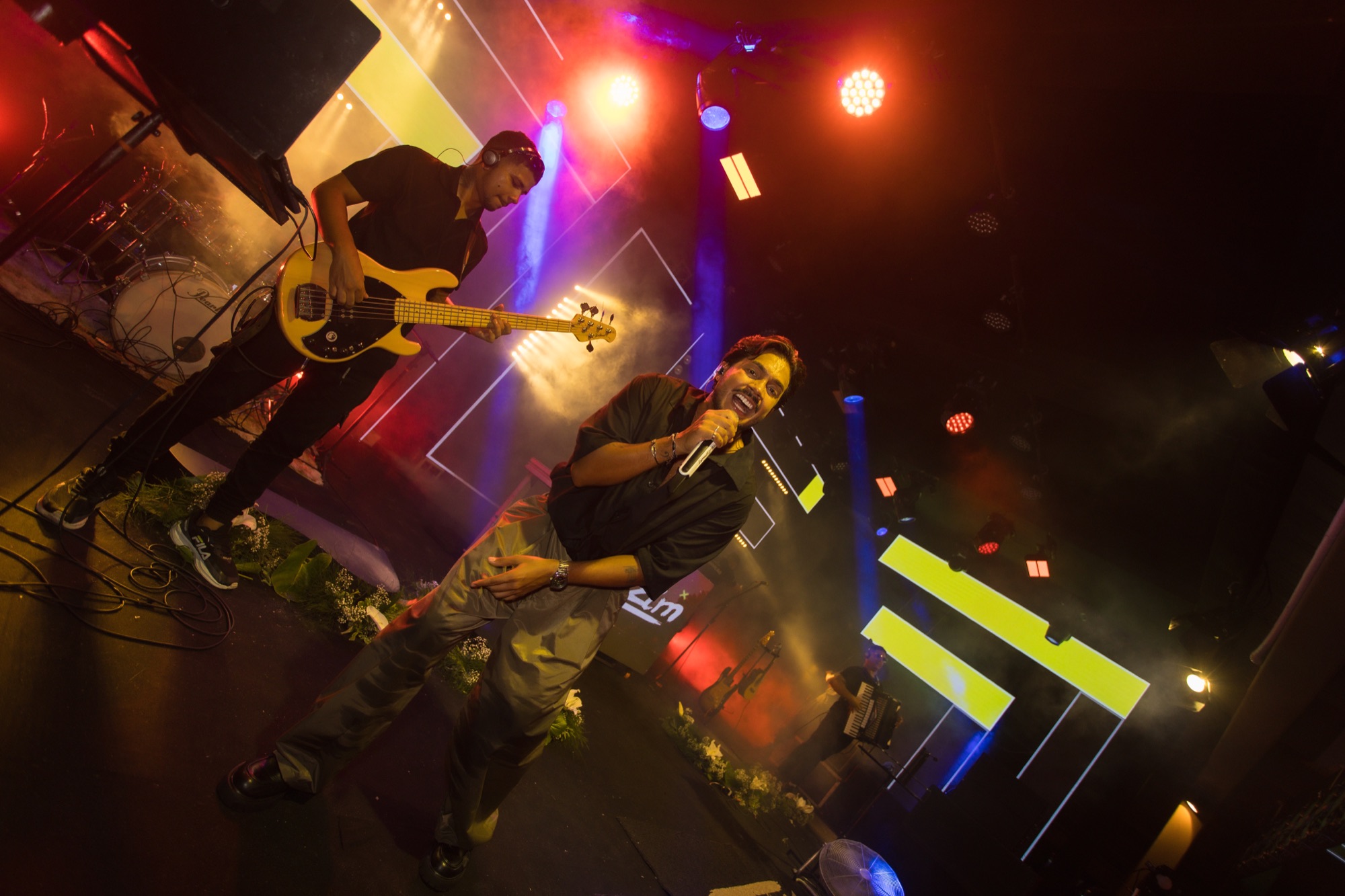 Levizim e baixista em um palco iluminado durante o show